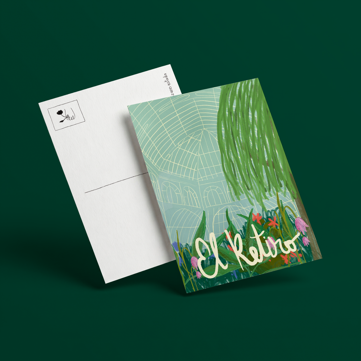 Postal ilustrada El Retiro de Alejandra Lozano: interior del Palacio de Cristal con un sauce verde, flores rosas, rojas y azules y las palabras El Retiro escritas a mano, junto al reverso blanco de la postal con recuadro para el sello.