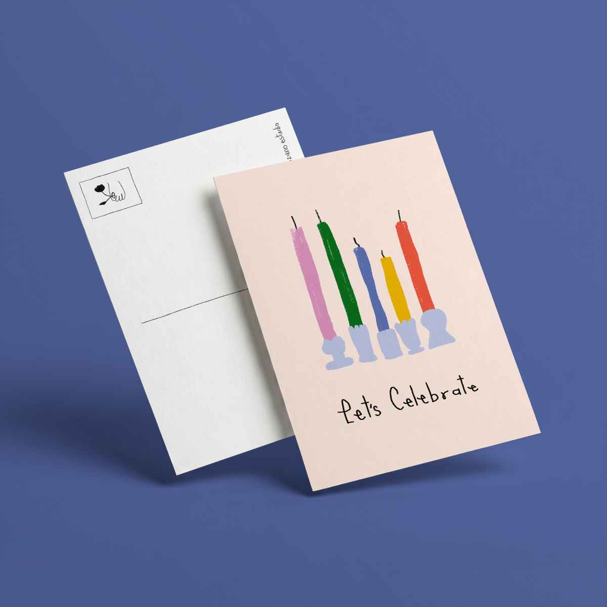 Postal ilustrada Let's Celebrate de Alejandra Lozano: cinco velas rosa, verde, azul, amarilla y roja en candelabros lilas sobre fondo rosa claro, junto al reverso blanco de la postal con recuadro para el sello.