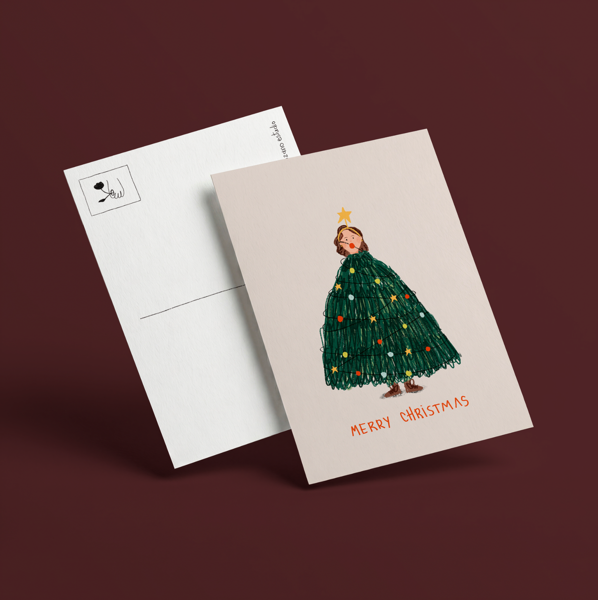 Postal ilustrada de Navidad de Alejandra Lozano: niña disfrazada de árbol de Navidad con luces de colores y diadema de estrella y las palabras Merry Christmas en rojo, junto al reverso blanco de la postal con recuadro para el sello.